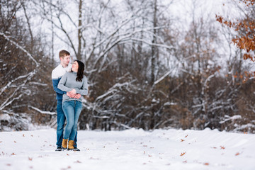 Love Valentine Concept. people, season, love and leisure concept - happy couple hugging and kissing outdoors in winter. Romantic couple in love feeling happiness romance Valentine . love copy space.