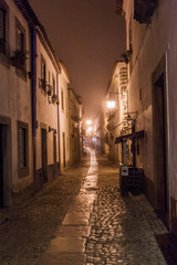 Fototapeta na wymiar Night view of a narrow cobbled street in Obidos village, Portugal