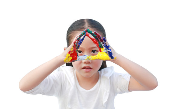 Portrait of Asian little girl looking through her colorful hands painted isolated on white background. Focus at child hands. Kid pose hands triangle in front of her eyes.