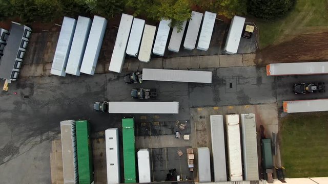 Top down aerial drone view of freight trailers at distribution center, logistics and transportation, e-commerce theme