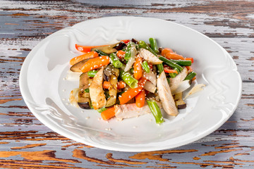 Cooked chicken with vegetables on a white plate