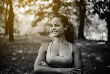 Attractive black woman smiles emotionally posing after break workout at outdoor,Positive thinking and smiling,Relax time,Black and white toned