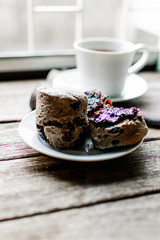 Sliced dried fruit chocolate scones with jam in the small saucer. 