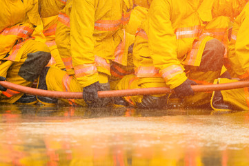 fireman fighting fire flame with water and extinguisher in training workshop, Teamwork and emergency concept