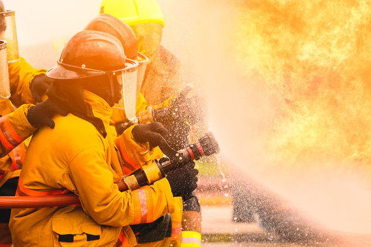 fireman fighting fire flame with water and extinguisher in training workshop, Teamwork and emergency concept