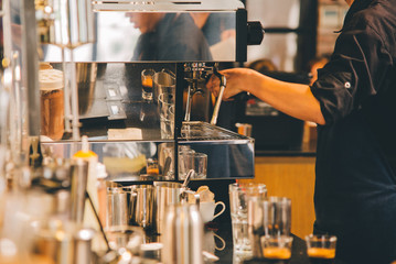 Women Barista to make a drip brewing, filtered coffee, or pour-over is a method which involves...