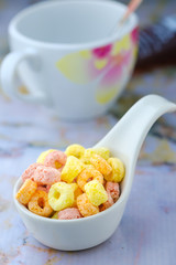 Cereal flakes in white spoon ceramic with copy space,Breakfast concept.Food with delicious fruity taste and fruity colours.It's made with maize,wheat,and barley