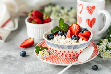 Cottage cheese with berries, jam, fresh strawberries and a cup of coffee with cream for breakfast. The recipe for the holiday Valentine's Day. Copy space