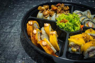 Delicious japanese traditional variation of sushi rolls, made with rice, eel sauce, crab, shrimp, plantain, avocado and gratin cheese