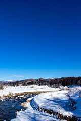 Fototapeta na wymiar 冬の青空と雪景色　秋田県仙北市西木町