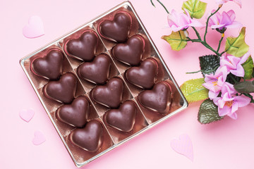 Concept Valentine's Day. Chocolate candies, hearts on a pink background