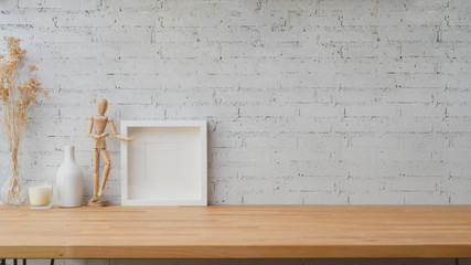 Close up view of modern workspace with wooden figure, frame and decorations on wooden table with...