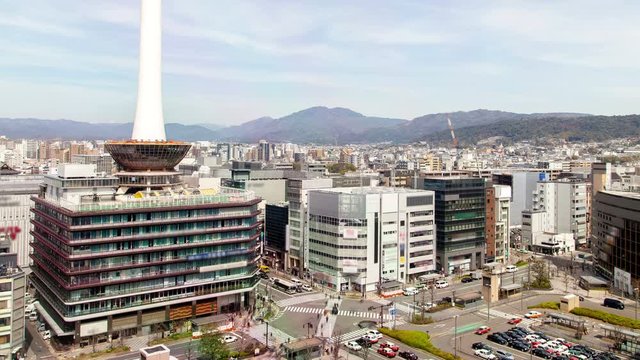 KYOTO/JAPAN - APRIL 30 2019: Timelapse Kyoto downtown large square busy traffic crossing with all-round crosswalks and nearby TV tower under cloudy sky on April 30 in Kyoto