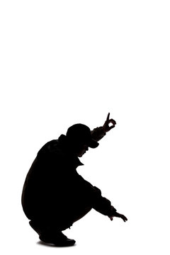 Silhouette of a male hiker or explorer isolated on a white background wearing a hat and clothes for trekking. He is searching or looking for something on the ground