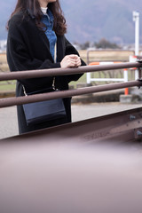 ロングヘアーの女性が橋のそばで笑顔でいる　woman longhair