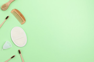 Eco-friendly supplies for personal hygiene. Zero waste composition on green background with copy space.