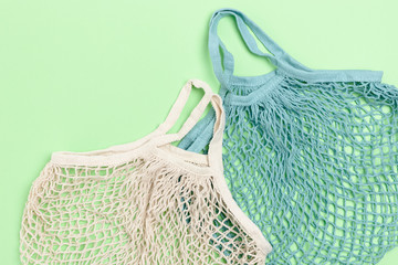 Composition with reusable shopping bags on green background.