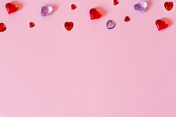 The background of Valentine's day. Border of beautiful different hearts on a pink background