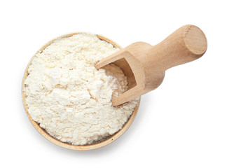 Bowl with flour and scoop on white background