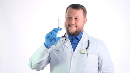 bearded male doctor in a white coat holds a syringe and a needle in his hands on a white isolated background. This is for you to get better