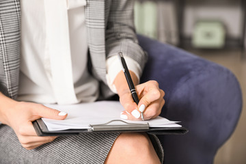 Female psychologist with clipboard in office, closeup