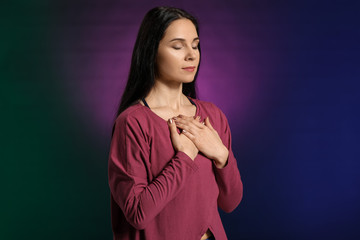 Meditating woman on dark color background