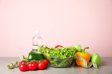 Different healthy food with measuring tape and dumbbells on table. Diet concept