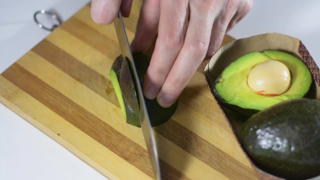 slices half the fresh avocad into slices. Wholesome healthy food