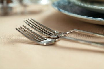 Silver cutlery on table top with tablecloth