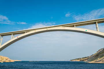 Bridge to the island Krk under blue sky on a sunny summer day. Krk is the big island of the Croatian coast of the Adriatic Sea. Travel landscape