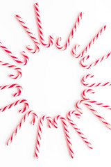 Christmas candies frame - cane with red and white stripes - on white background top-down copy space