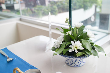 White flower with green leat on ceramics container