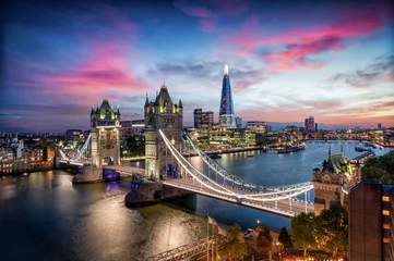 Fototapeten Blick auf die Tower Brücke und die Skyline von London mit den beleuchteten Hochhäusern an der Themse nach Sonnenuntergang, Großbritannien © moofushi