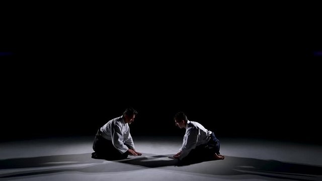 Two Masters martial arts Aikido Bow to Each Other. Shot Isolated on Black and White Background. Slow motion