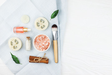 Homemade spa cosmetic set with salt and oil on white wooden background. Copy space. Flat lay style.
