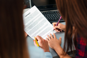 Fototapeta premium close up sign a contract. Female hands hold a pen