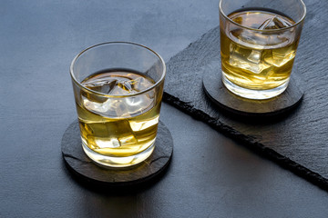 Scotch - two glasses with ice - on black background