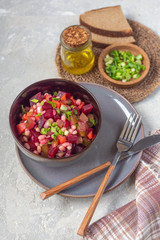 Close-up of vinaigrette salad in a dark plate with traditional cutlery