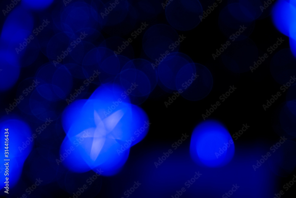 Wall mural defocused of blurred phantom blue star bokeh circle light from lighting bulb in the dark night for a