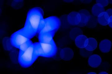 Defocused of blurred phantom blue star bokeh circle light from lighting bulb in the dark night for...