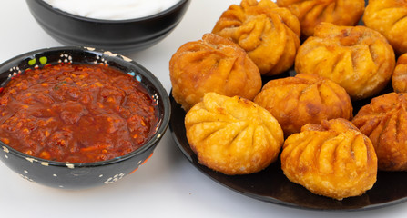 Fried Momos is a Traditional Dumpling Food From Nepal Served with Schezwan Sauce & Cream