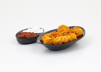 Fried Momos is a Traditional Dumpling Food From Nepal Served with Schezwan Sauce & Cream