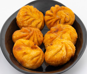 Fried Momos is a Traditional Dumpling Food From Nepal Served with Schezwan Sauce & Cream