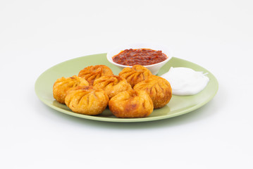 Fried Momos is a Traditional Dumpling Food From Nepal Served with Schezwan Sauce & Cream