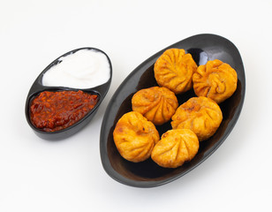 Fried Momos is a Traditional Dumpling Food From Nepal Served with Schezwan Sauce & Cream