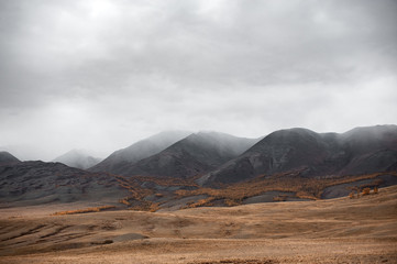 gloomy landscape of high gray mountain redhead in autumn