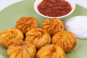Fried Momos is a Traditional Dumpling Food From Nepal Served with Schezwan Sauce & Cream