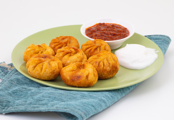 Fried Momos is a Traditional Dumpling Food From Nepal Served with Schezwan Sauce & Cream