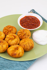 Fried Momos is a Traditional Dumpling Food From Nepal Served with Schezwan Sauce & Cream