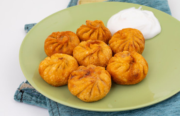Fried Momos is a Traditional Dumpling Food From Nepal Served with Schezwan Sauce & Cream